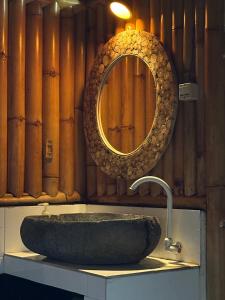 a bathroom with a stone sink and a mirror at Bambuu in Gili Islands