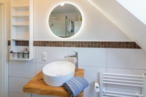 a bathroom with a sink and a mirror at Küstenkoje in Neßmersiel +17 photos