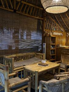 a room with a table and chairs and a room with a bed at Bambuu in Gili Islands +30 photos