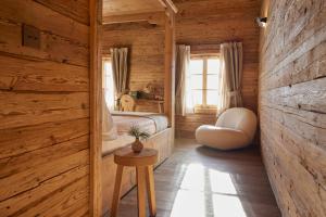 a bedroom in a log cabin with a bed and a table at Berghuus Radons in Savognin
