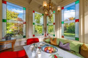 a living room with a table and some windows at Hotel Design Villa Ottilienruh in Ilsenburg