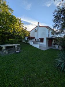 a building with a picnic table in the grass at Hiša Seča Sunset in Portorož