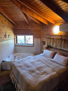 a bedroom with a large bed and a bath tub at Among the cherry trees B&B 6 - Nahal Dan in Metulla