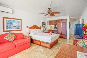 a bedroom with a bed and a red couch at Islander on the Beach 131 in Kapaa +46 photos