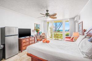 a bedroom with a large bed and a refrigerator at Islander on the Beach 131 in Kapaa