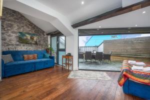 a living room with a blue couch and a stone wall at Luxury Barbican Apartment in Plymouth