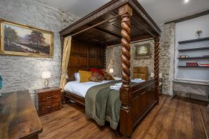 a bedroom with a canopy bed in a stone wall at Luxury Barbican Apartment in Plymouth +103 photos