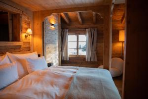 a bedroom with a white bed in a room with a window at Berghuus Radons in Savognin