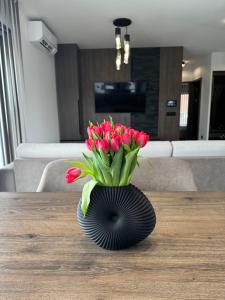 a vase of red tulips sitting on a table at BODU Vendégház in Balatonberény