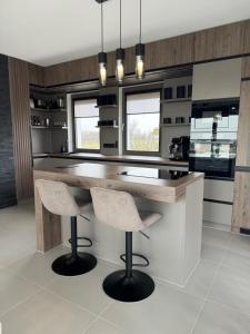a kitchen with a wooden counter and two bar stools at BODU Vendégház in Balatonberény +2 photos
