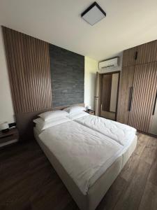 a bedroom with a large bed with white sheets and pillows at BODU Vendégház in Balatonberény