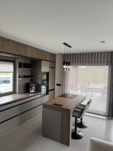 a kitchen with a wooden table and a dining room at BODU Vendégház in Balatonberény