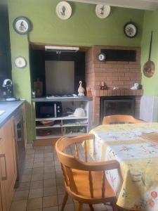 a kitchen with a table and a tv in a room at Ici c'est chouette in Vaudricourt