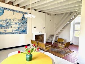 a living room with a table and chairs and a staircase at Villa Paignon Gite in Montbron