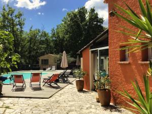 a patio with chairs and a swimming pool at Les Mazets de la Cascade in Salernes