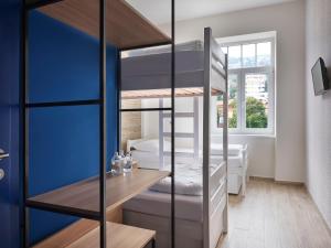 a bedroom with a bunk bed with blue walls at Hostel Link in Lovran