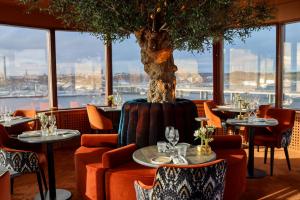 a restaurant with tables and chairs and a tree at Villa Foresta in Lidingö