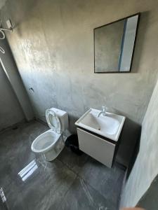 a bathroom with a toilet and a sink and a mirror at Pousada Amizade in Água Boa