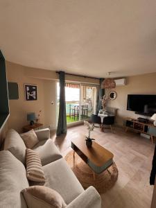 a living room with a couch and a table at Bleu Azur -Vue Mer 6e Etage - Triangle d'Or in Saint-Raphaël