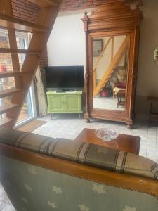 a living room with a couch and a television at Ici c'est chouette in Vaudricourt