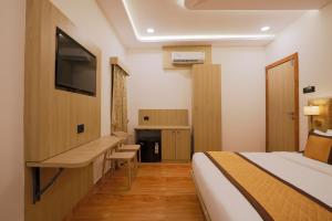 a hotel room with a bed and a flat screen tv at De Classico Hotel Apartment in Mumbai +19 photos