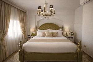 a bedroom with a large bed and a chandelier at Royal stylish view apartment in Koropi