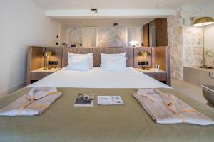 a bedroom with a large bed with two pillows at Santa Boka Small Luxury Hotels of the World in Perast +134 photos