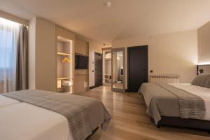 ein Hotelzimmer mit zwei Betten und einem Flur in der Unterkunft Hotel Màgic Pas by Nexta in Pas de la Casa + 28 Fotos
