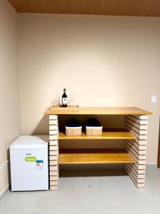 a shelf in a kitchen with two baskets and a refrigerator at Recanto Tavares in Linhares