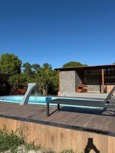 a swimming pool with a picnic table and a bench at Recanto Tavares in Linhares
