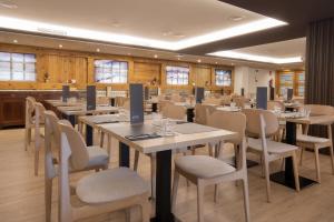 ein Konferenzraum mit Tischen, Stühlen und Fenstern in der Unterkunft Hotel Màgic Pas by Nexta in Pas de la Casa