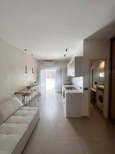 a living room and kitchen with a couch and a table at Little Kamara Ios in Ios Chora