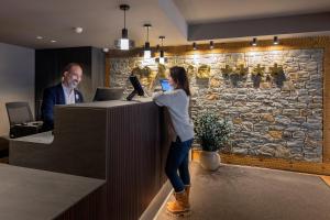 Eine Frau steht an einem Schalter in einem Büro. in der Unterkunft Hotel Màgic Pas by Nexta in Pas de la Casa