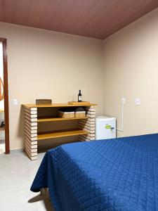 a bedroom with a blue bed and a dresser at Recanto Tavares in Linhares