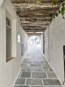an alley in a building with a wooden ceiling at Little Kamara Ios in Ios Chora