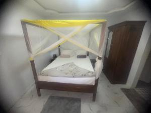 a small bed with a canopy in a room at Appartement privatif À Mbour face RN1 in Mbour