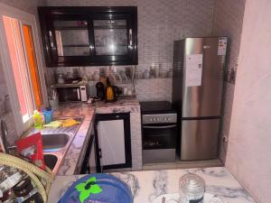 a kitchen with a stainless steel refrigerator and a sink at Appartement privatif À Mbour face RN1 in Mbour