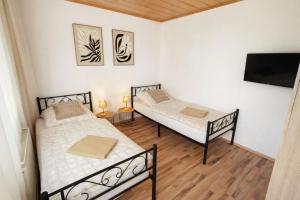 two beds in a room with a flat screen tv at Ferienwohnung Wie dehemm in Sankt Ingbert
