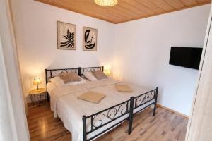a bedroom with a bed and a flat screen tv at Ferienwohnung Wie dehemm in Sankt Ingbert
