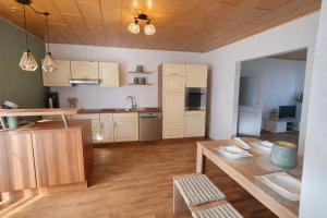 a kitchen with white cabinets and a wooden floor at Ferienwohnung Wie dehemm in Sankt Ingbert