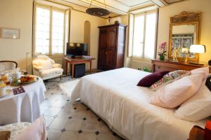 a bedroom with a large white bed and a chair at Une chambre au Château in Cabriès