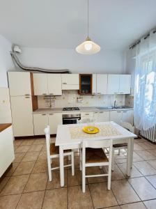 a white kitchen with a white table and chairs at Casa Acqua e Sale - 50 mt dal mare in Fano