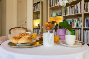 a table with a plate of croissants and orange juice at Une chambre au Château in Cabriès