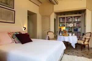 a bedroom with a white bed and a table at Une chambre au Château in Cabriès
