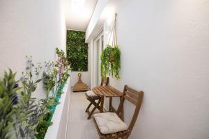 a porch with two chairs and a table and flowers at Almond Jacuzzi Suites - Private Indoor Jacuzzi - Self Check-In - Free & Easy Street Parking in Thessaloniki