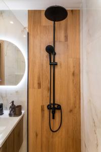 a shower in a bathroom with a wooden wall at Almond Jacuzzi Suites - Private Indoor Jacuzzi - Self Check-In - Free & Easy Street Parking in Thessaloniki +40 photos