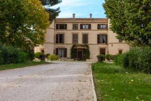 an old house with a driveway in front of it at Une chambre au Château in Cabriès