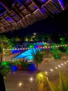 a pool with lights in a resort at night at Nilio Explorer & Lodge in Mfumbwi