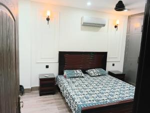 a bedroom with a bed in a white room at Alfazal apartment in Lahore