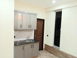 a kitchen with white cabinets and a sink at Alfazal apartment in Lahore